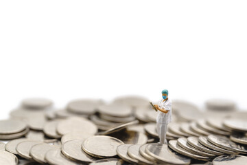 Fototapeta na wymiar Business, Money Healthcare Concept. Docter miniature figure people wearing cap and face mask with patient file standing on pile of coins cutout isolated white background.
