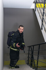 firefighter climbs up the stairs with breathing apparatus
