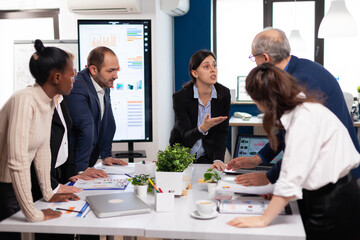 Group of diverse businesspeople meeting brainstorm ideas about new paperwork finance project. Multiethnic colleagues working planning success financial strategy discussing in office