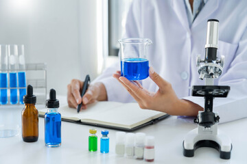 Fototapeta premium Scientist wear lab coat and protective wear are working with research or doing investigations with test tubes in experiment, Laboratory and development concept