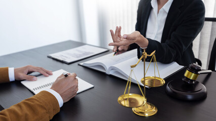 law,libra scale and hammer on the table, 2 lawyers are discussing about legal provision, law...