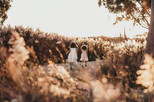 two girls running through grass