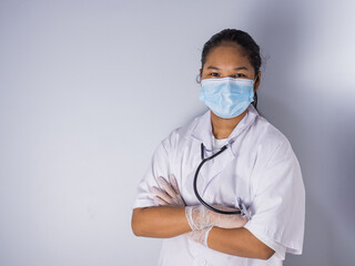 Studio portrait of a female doctor wearing a mask standing on a white background There was a slight light on his face.