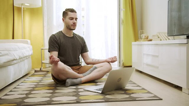 An attractive young man is making healthy exercises on the Internet 