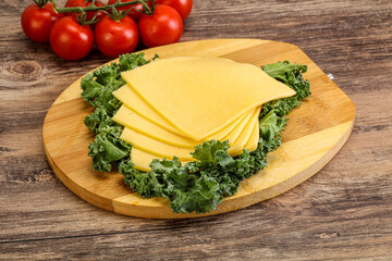 Sliced Gauda cheese over board