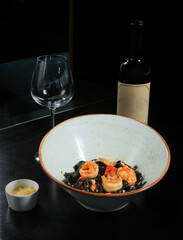 exquisite gourmet mediterranean food with rice noodles and shrimp accompanied with a delicious wine.