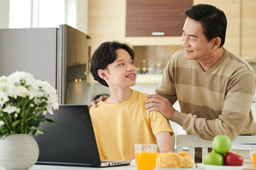 Caring father serving lunch for his teenage son studying at home due to coronavirus pandemic