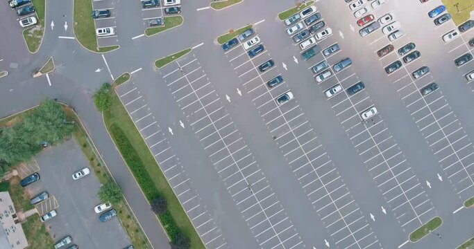 The Parking lot is almost completely filled with colorful cars from the height of bird flight.