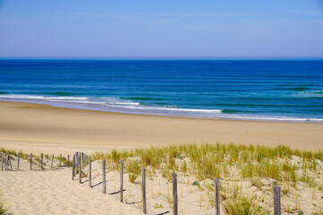 beach sea access in sandy dunes and fence of atlantic ocean waves at le porge coast in france - obrazy, fototapety, plakaty