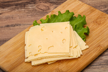 Sliced yellow cheese over board