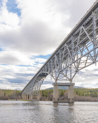 Johnsons Crossing Bridge over Teslin River in northern Canada during spring, summer time with steel beams running above and blue sky in background along the Alaska Highway, Yukon Territory.