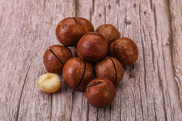 Brown macadamia nut heap over background