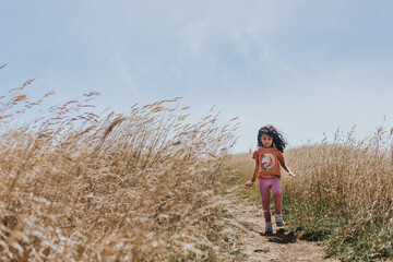 Little girl walking on a coastal path