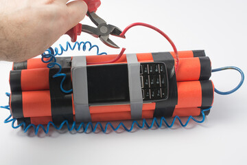 a man with side cutters wants to cut the red wire on the bomb so that an explosion does not occur....