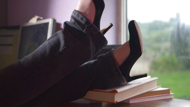 Woman puts feet up on desk at work
