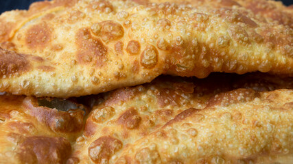Cheburek - fried pie with meat and onions on a plate. Traditional dish of many turkic and mongolian peoples