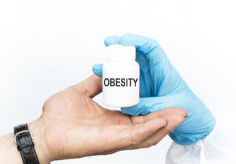 on a white background a doctor's hand with a jar with the inscription obesity gives to the patient's hand, treatment