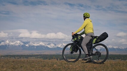 The man travel on mixed terrain cycle touring with bikepacking. The traveler journey with bicycle...