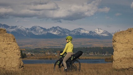 The woman travel on mixed terrain cycle touring with bikepacking. The traveler journey with bicycle...