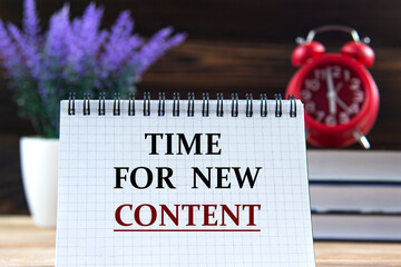 TIME FOR NEW CONTENT - words in a notebook against the background of books, alarm clock and lavender