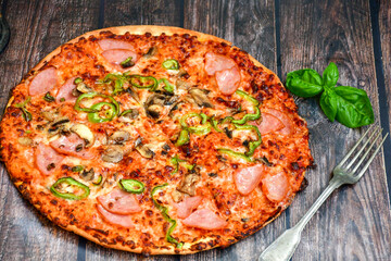  Close up of    hot italian pizza   classic ham. Fresh basil,tomato sauce ,mozzarella cheese , mushrooms and  minced meat .Concept poster for Restaurants or pizzerias. Top view