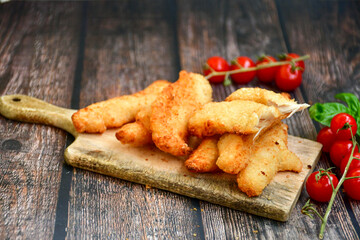 
 Crispy  deep fried home made    chicken strips Breaded  with  almond flour chicken  breast fillets  with chilly peppers and fresh   basil on wooden rustic background. Ketogenic diet food