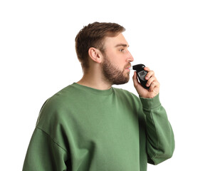 Man blowing into breathalyzer on white background