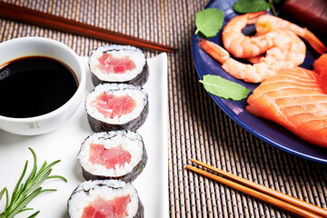 Japanese sushi plate with a plate with salmon, tuna and shrimp and wooden chopsticks. Delicious Japanese food