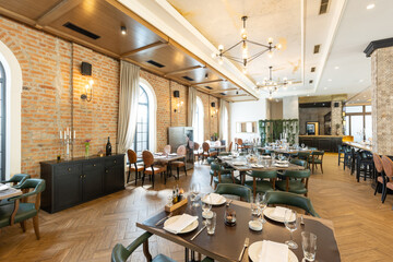 Interior of an empty large hotel restaurant with brick walls