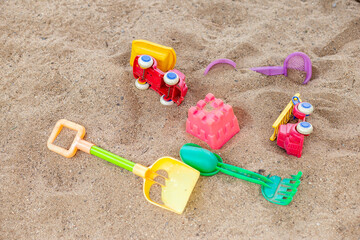 Fototapeta na wymiar selective focus colorful children's toys on the sand Toy car and toy shovel concept in the technology age Children only play mobile phone games. They don't play with toys like before.