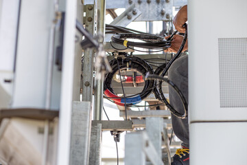 Installing a new mobile network cable behind the phone control cabinet To upgrade to a 5G network, the work of electrical engineers in Thailand