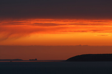 Sunset over the Irish Sea from Penmaenmawr, Wales with a silhouette containers ship on the horizon. Concept is Peace and serenity