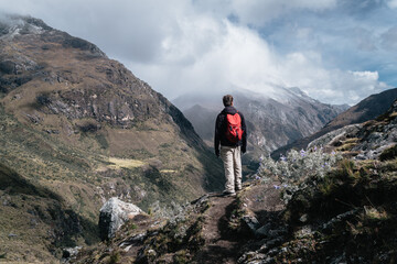 Man with backpack looking at mountains in Huascaran National Park. Peru