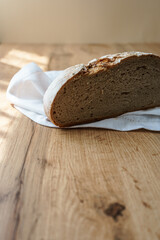Ein knuspriger halbierter Brotlaib auf einer weißen Serviette. Holz Tisch, rustikal.