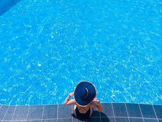 Fototapeta na wymiar Beautiful woman in pool in hotel. Summer holidays, enjoying summer vacations during quarantine. Aerial drone view