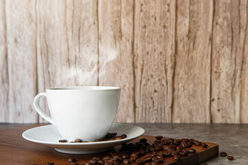 Cup of coffee and coffee beans on old wooden background