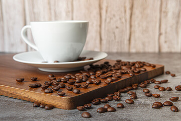 Cup of coffee and coffee beans on old wooden background