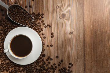 Cup of coffee and coffee beans on old wooden background