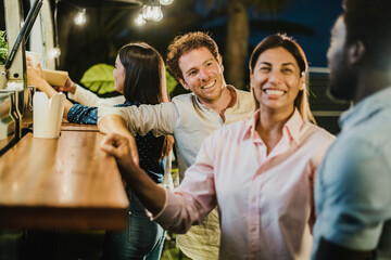 Multiracial friends talking outside food truck