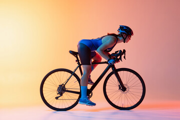Female cyclist riding a bicycle isolated against neon background
