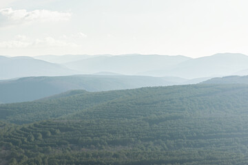 Mountains blue smoky landscape. Beautiful atmospheric morning misty forest. Neutral cold natural background. Lines of mountains in a blue haze. The concept of silence, tranquility, unity with nature.