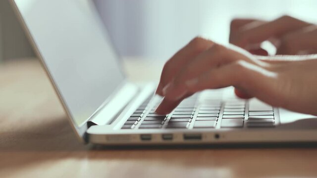 Closeup - Female hands professional user worker using typing on laptop notebook keyboard at home, working online with computer pc.