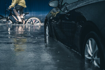 car in a deep puddle. downpour in the city. flooded car. flood in the city. - obrazy, fototapety, plakaty