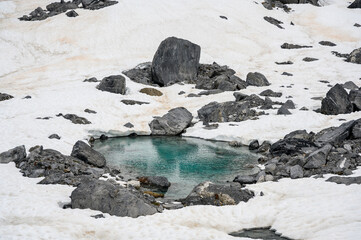 meltwater pond surrounded by snow in the Glarus Alps