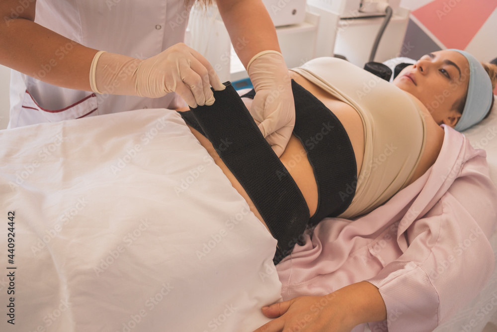 Poster Female physical therapist doing electrostimulation therapy on a woman in the spa