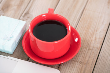 A cup of coffee next to the laptop