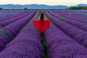 Zelfklevend Fotobehang Lavender field in Provence France running in red dress.  © Dr. Ina Melny