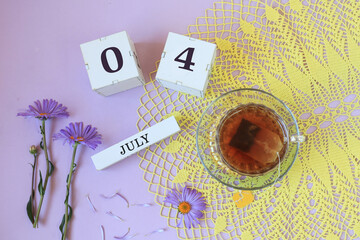 Calendar for July 4: cubes with the numbers 0 and 4, the name of the month of July in English , a...