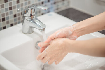 Woman using foam soap washing hands. Hygiene concept hand detail.