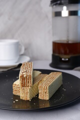 Waffles on a black plate on a blurred background.